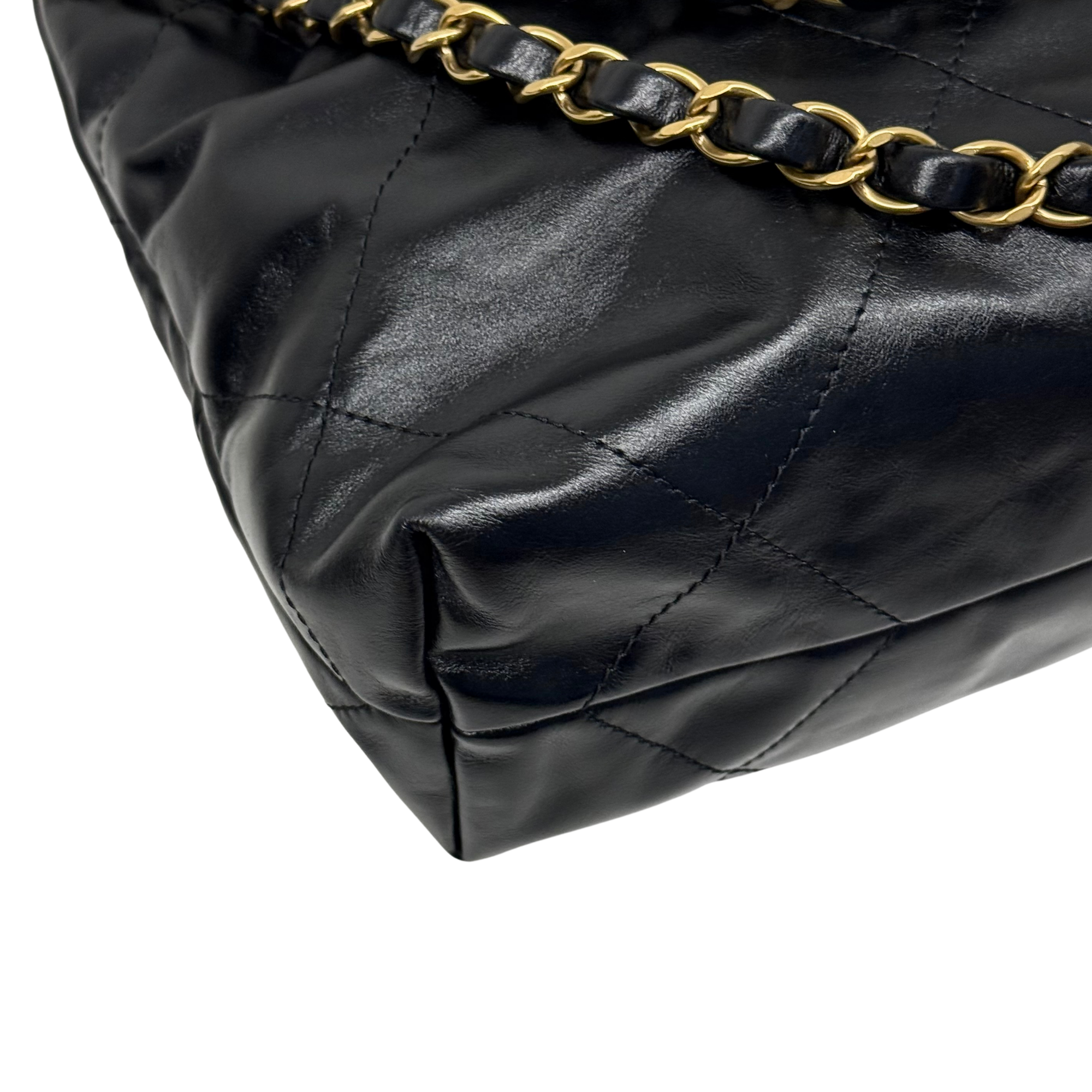 Black quilted leather shoulder bag with gold-tone chain strap across top seam detail