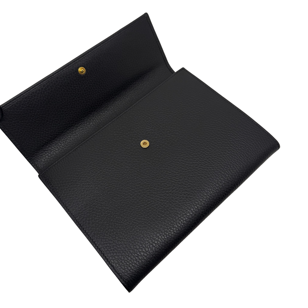 Black leather wallet with gold logo stud and flap closure, interior view