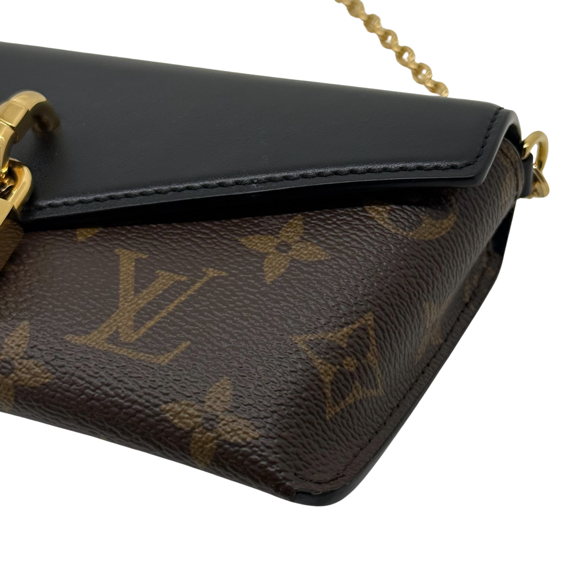 Black leather flap and brown monogram canvas corner with gold-tone hardware