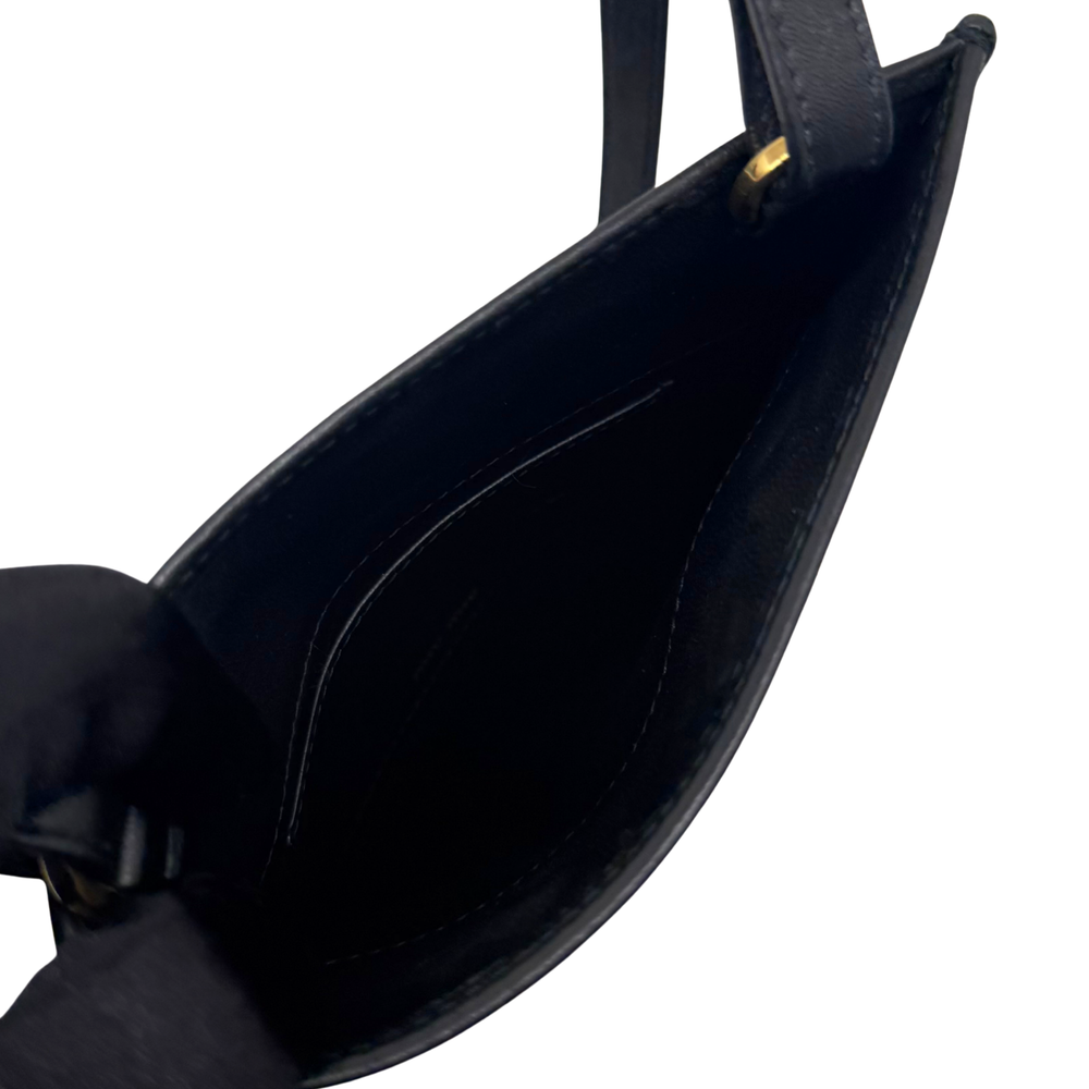 Black leather mini bag opening with interior lining and metal hardware