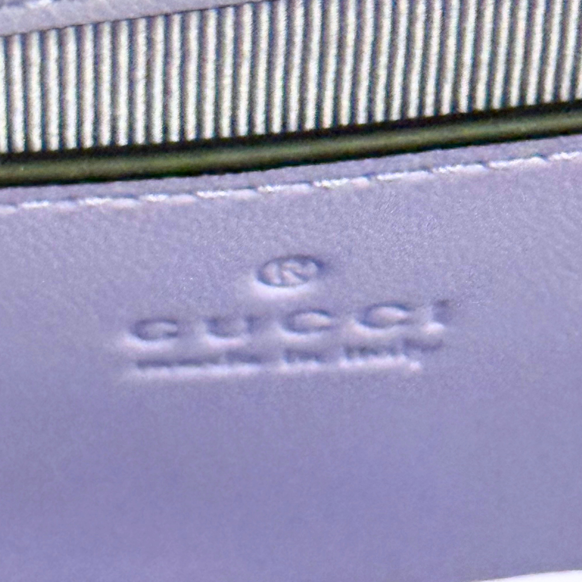 Lavender leather bag with small embossed logo stamp on front strap