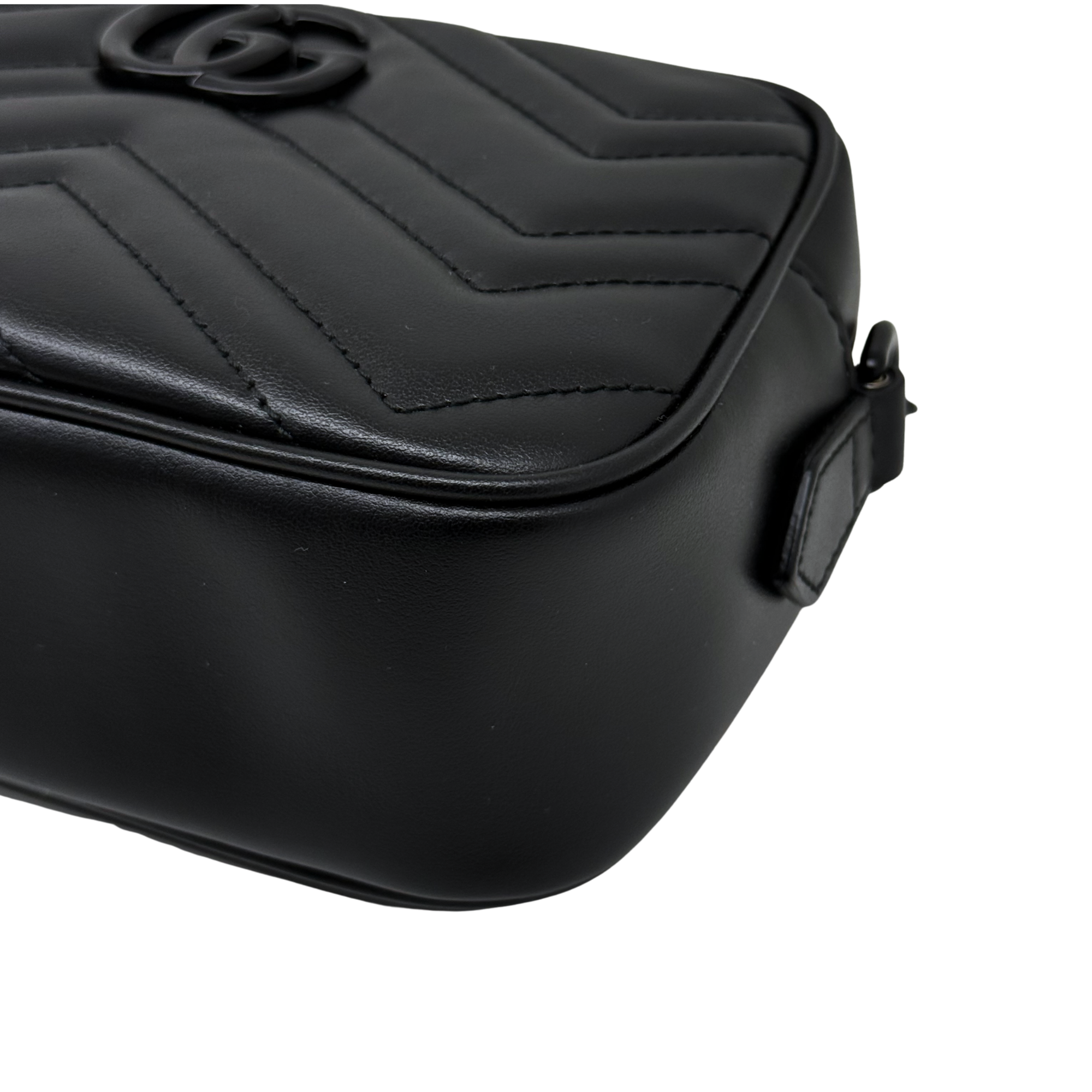Black leather mini crossbody bag with quilted panels and top flap, side close-up.