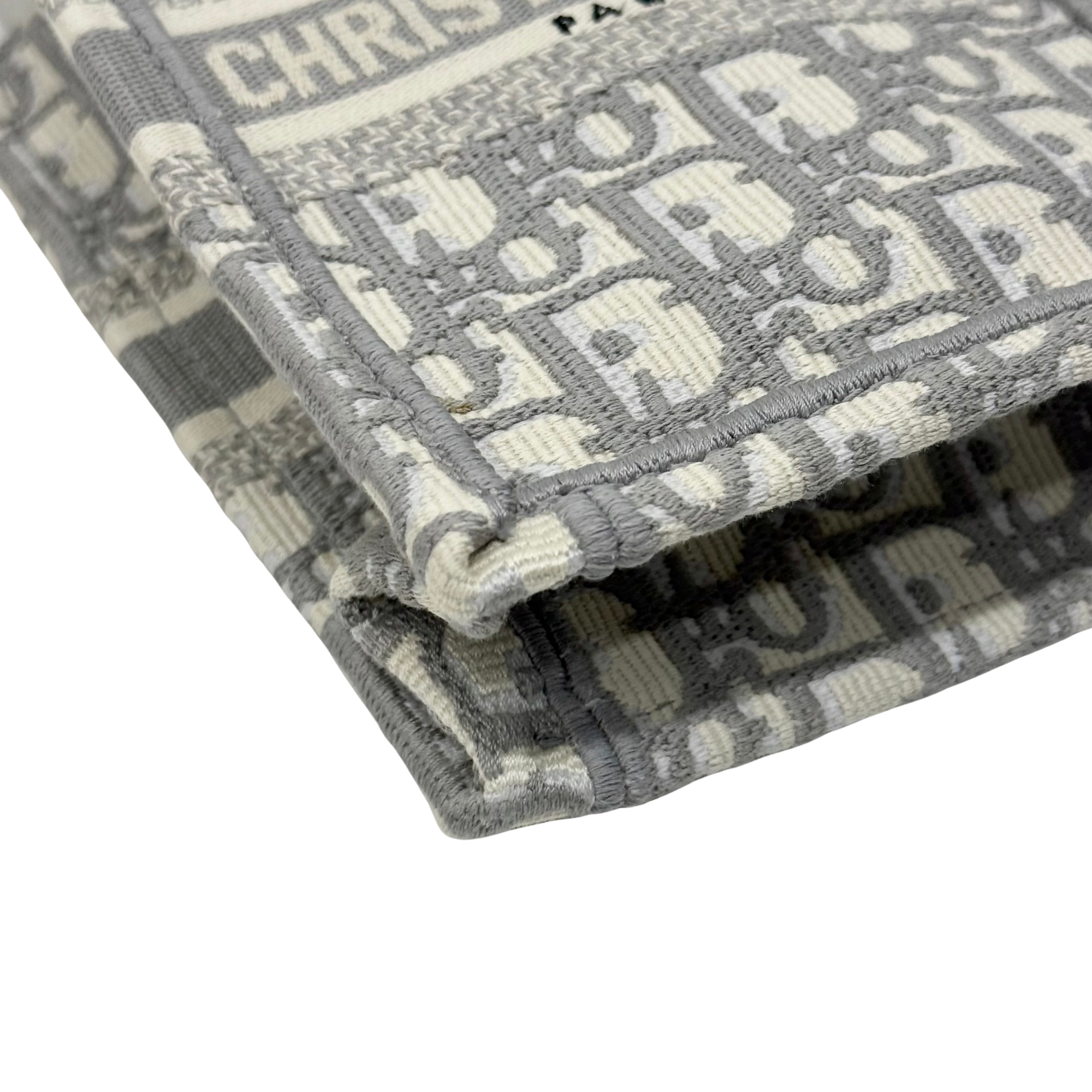 Gray-and-beige Dior monogram tote bag edge close-up with stitched border