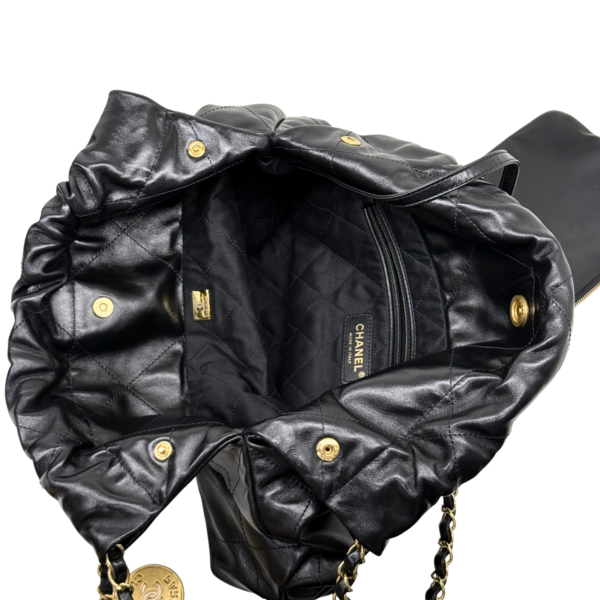 Black quilted leather bag with gold hardware, zipper pocket, and chain straps