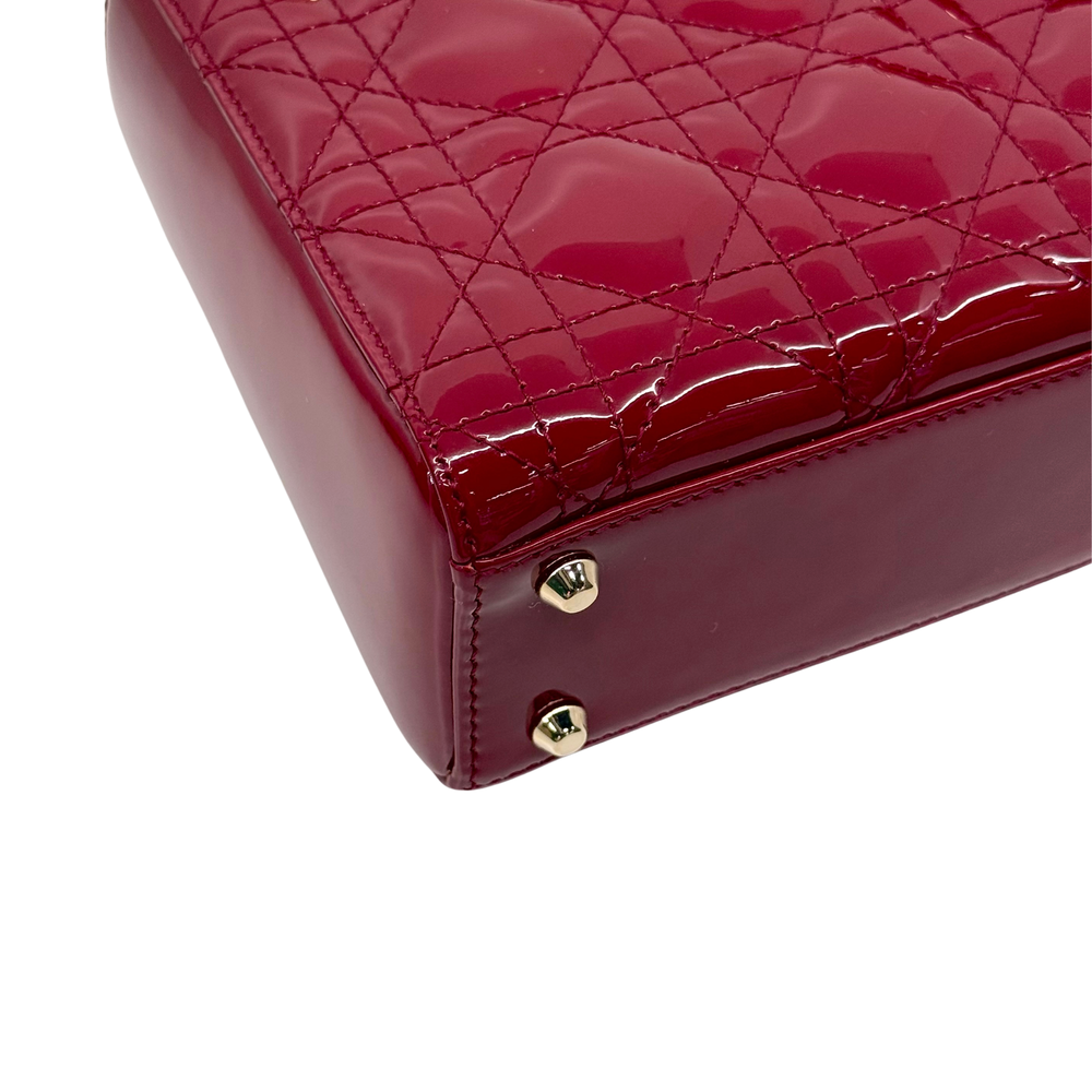 Red quilted patent leather mini handbag with gold snap buttons on the front