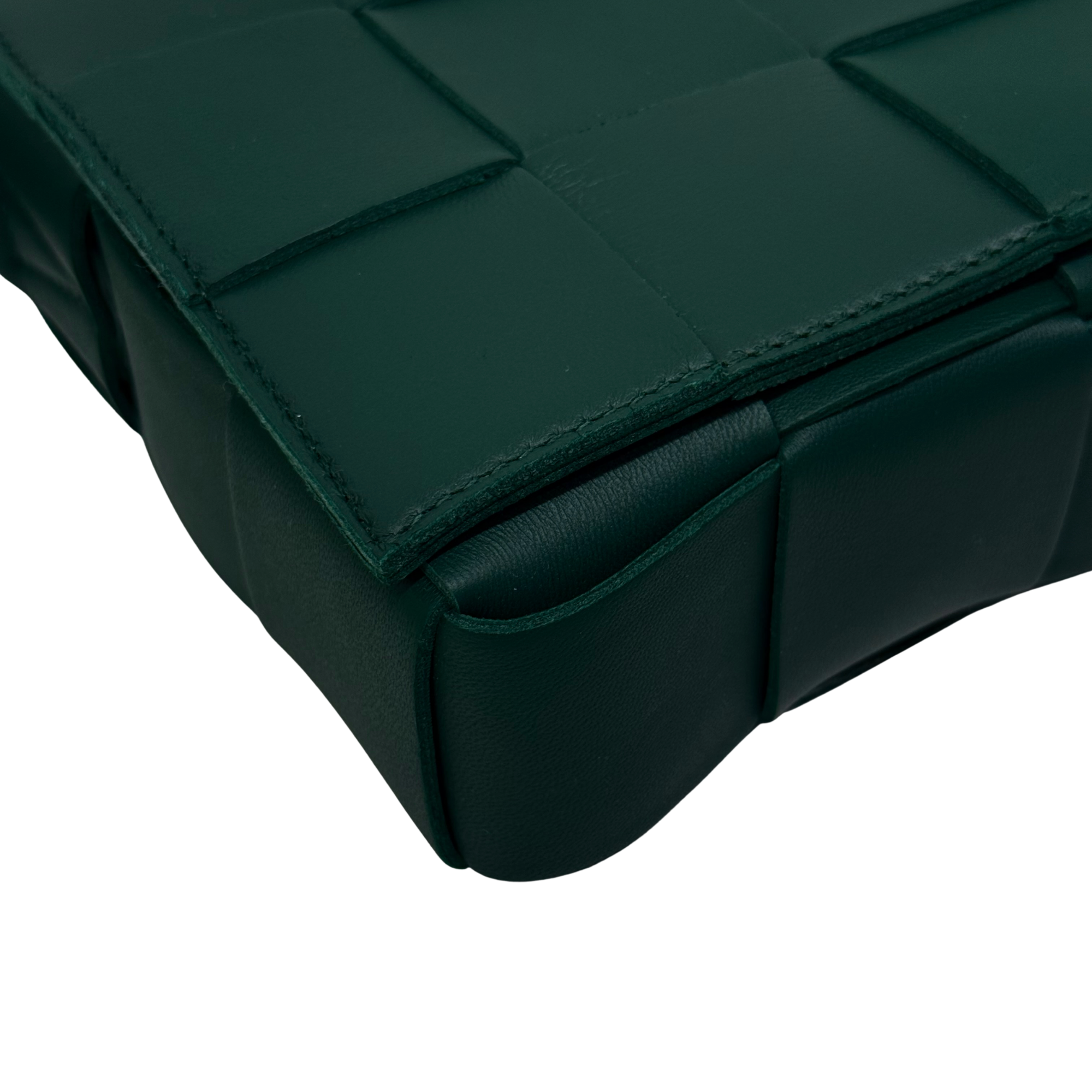 Green leather corner with stitched panel seams and rounded base