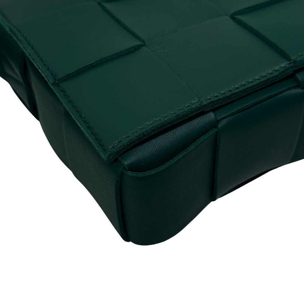 Green leather corner with stitched panel seams and rounded base