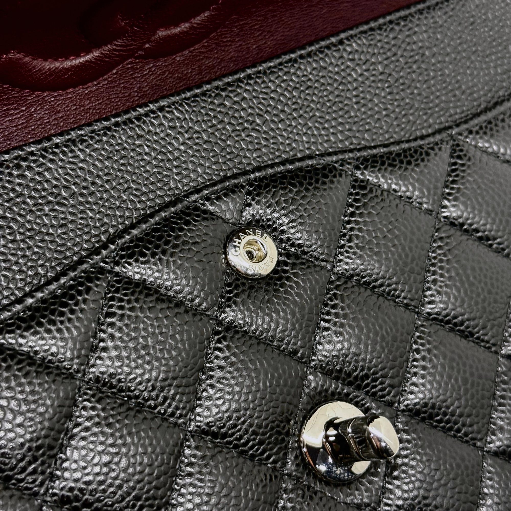 Quilted black leather flap with Chanel CC snap button and glossy metal clasp
