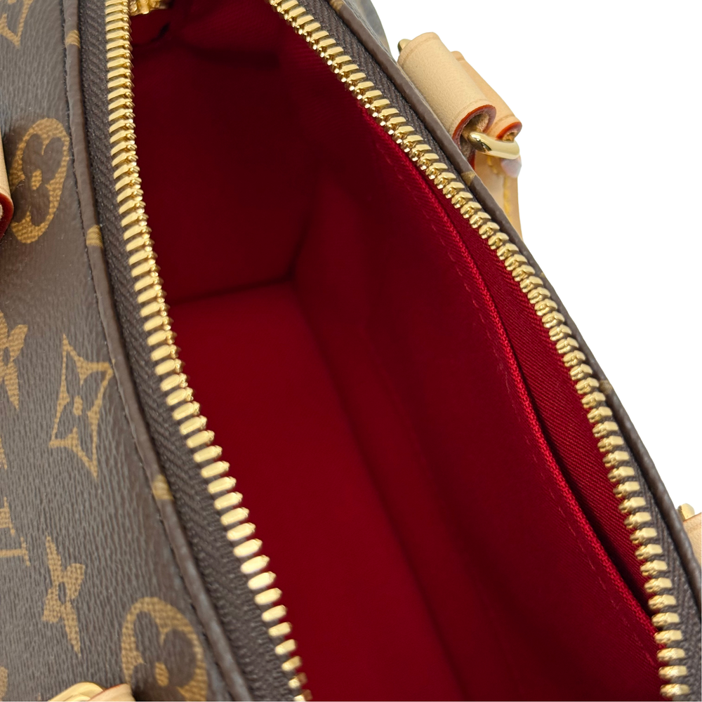 Louis Vuitton monogram handbag interior with gold zipper and deep red lining