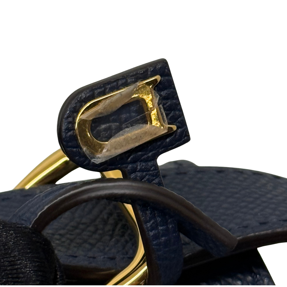 Navy leather shoulder bag detail: gold-tone clasp hinge and strap loop