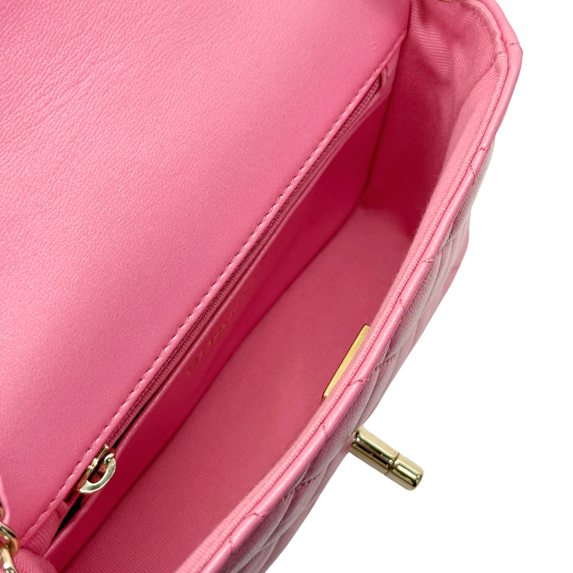 Pink quilted mini bag interior with zip pull and slip pocket opening