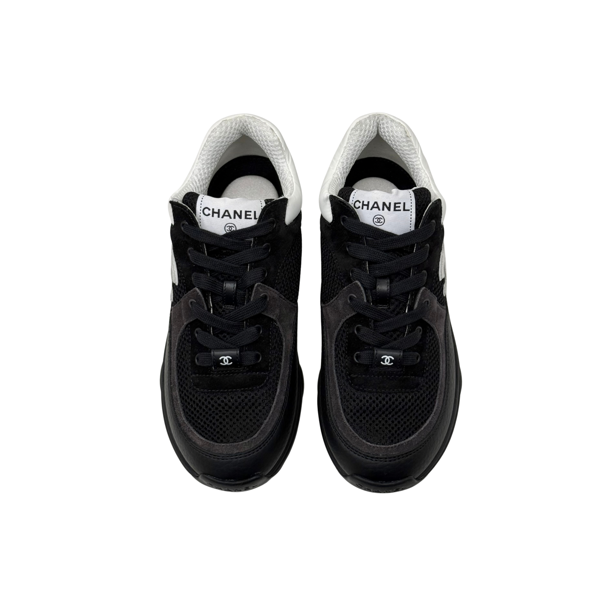 Black low-top sneakers with white collars and lace-up front, padded tongue.