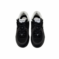 Black low-top sneakers with white collars and lace-up front, padded tongue.