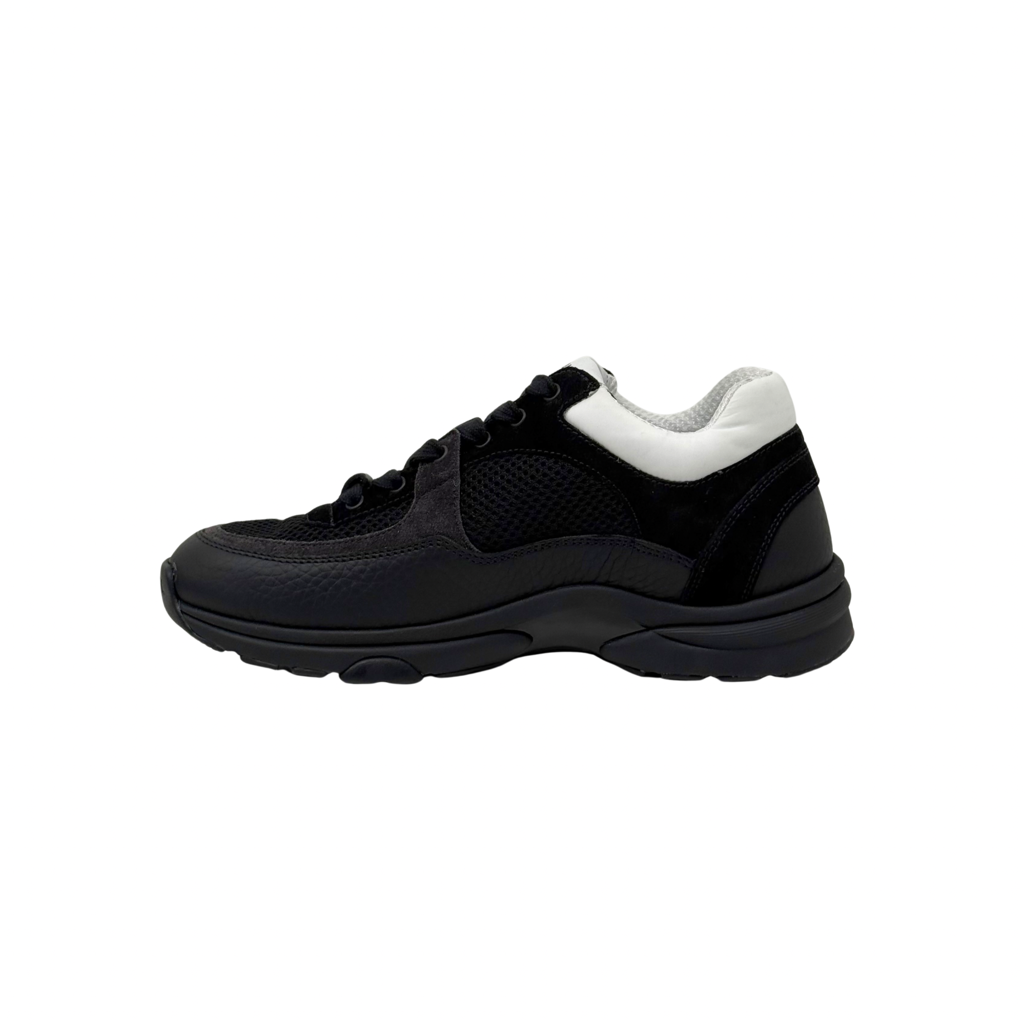 Black low-top sneakers with white heel tab, lace-up front, thick rubber sole.