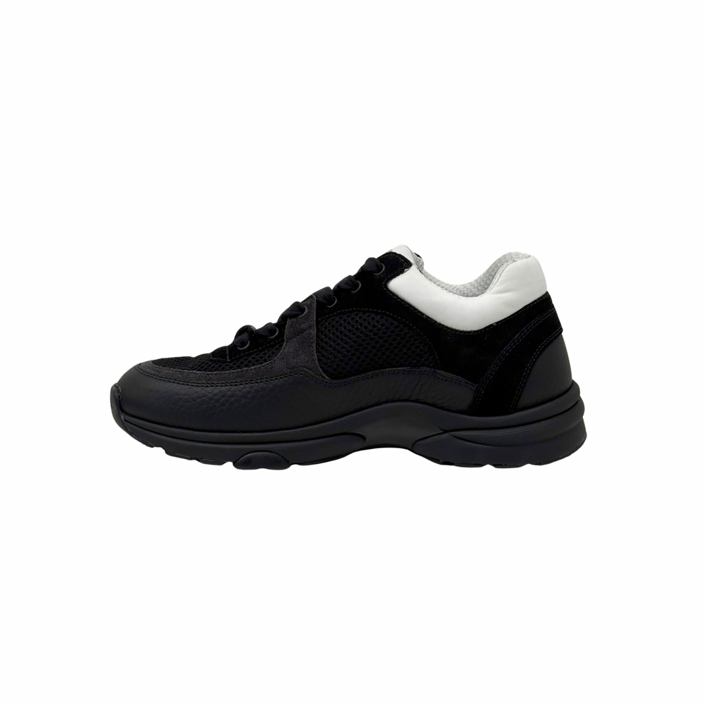 Black low-top sneakers with white heel tab, lace-up front, thick rubber sole.
