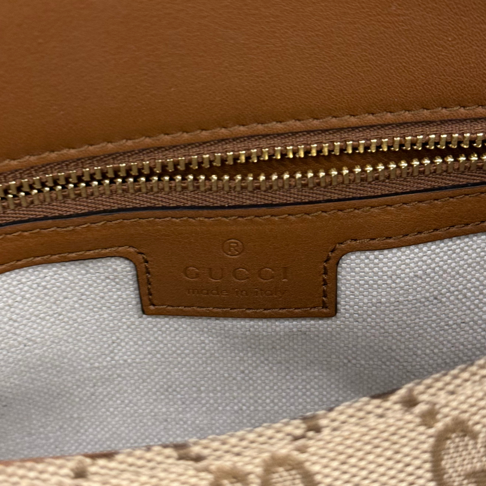 Gucci brown leather label and zipper detail on GG canvas bag