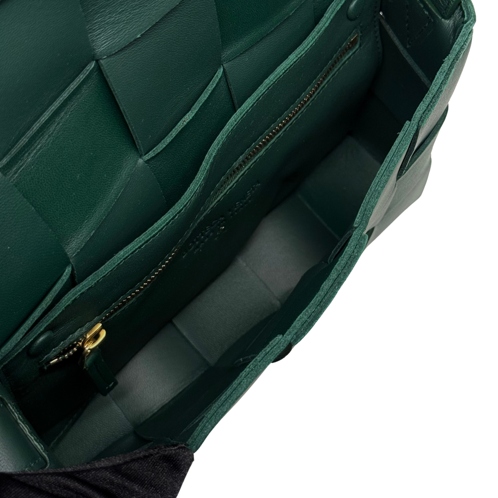 Green leather crossbody bag interior view with stitched panels and zipper