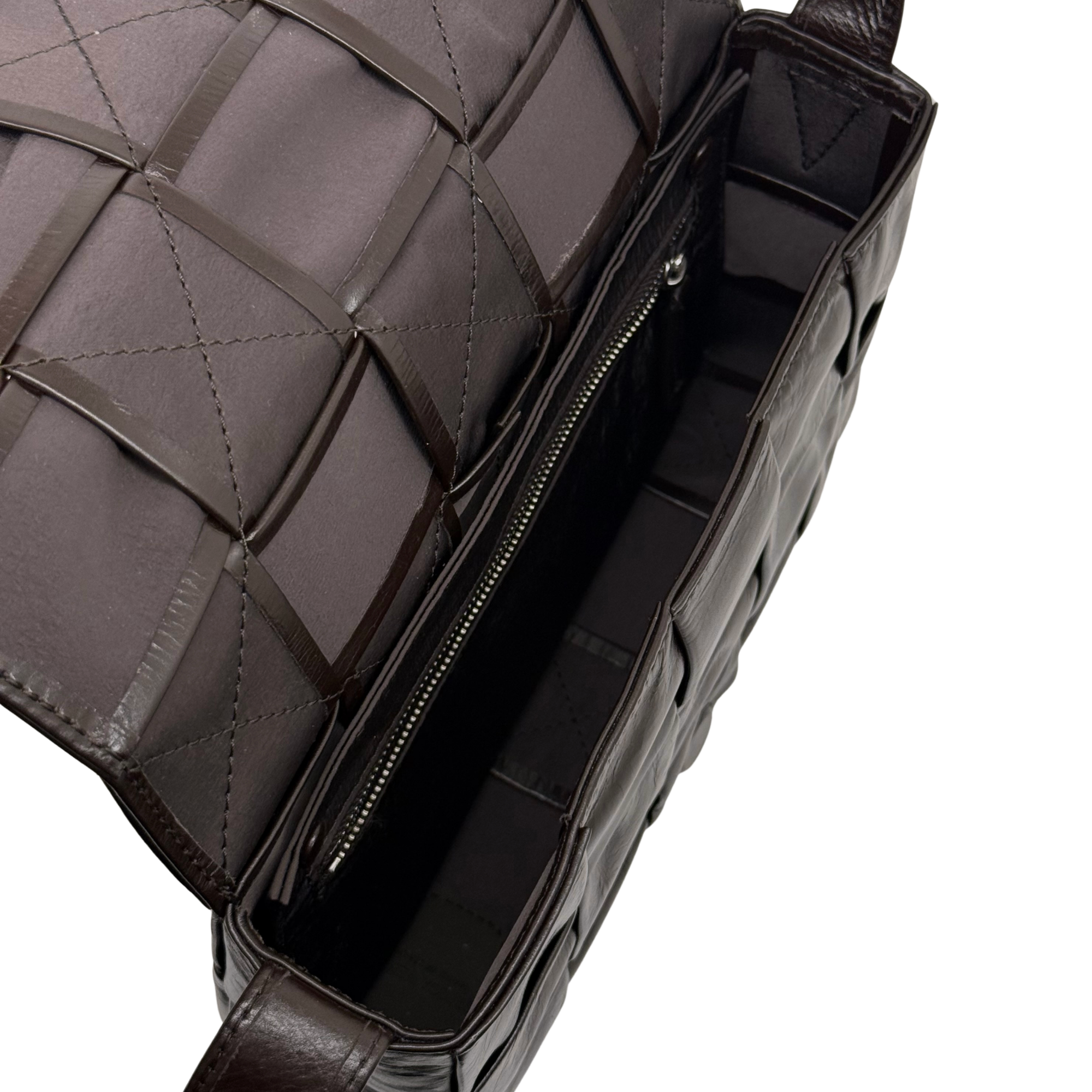Bottega quilted bag with dark zipper opening, lined interior, and braided strap