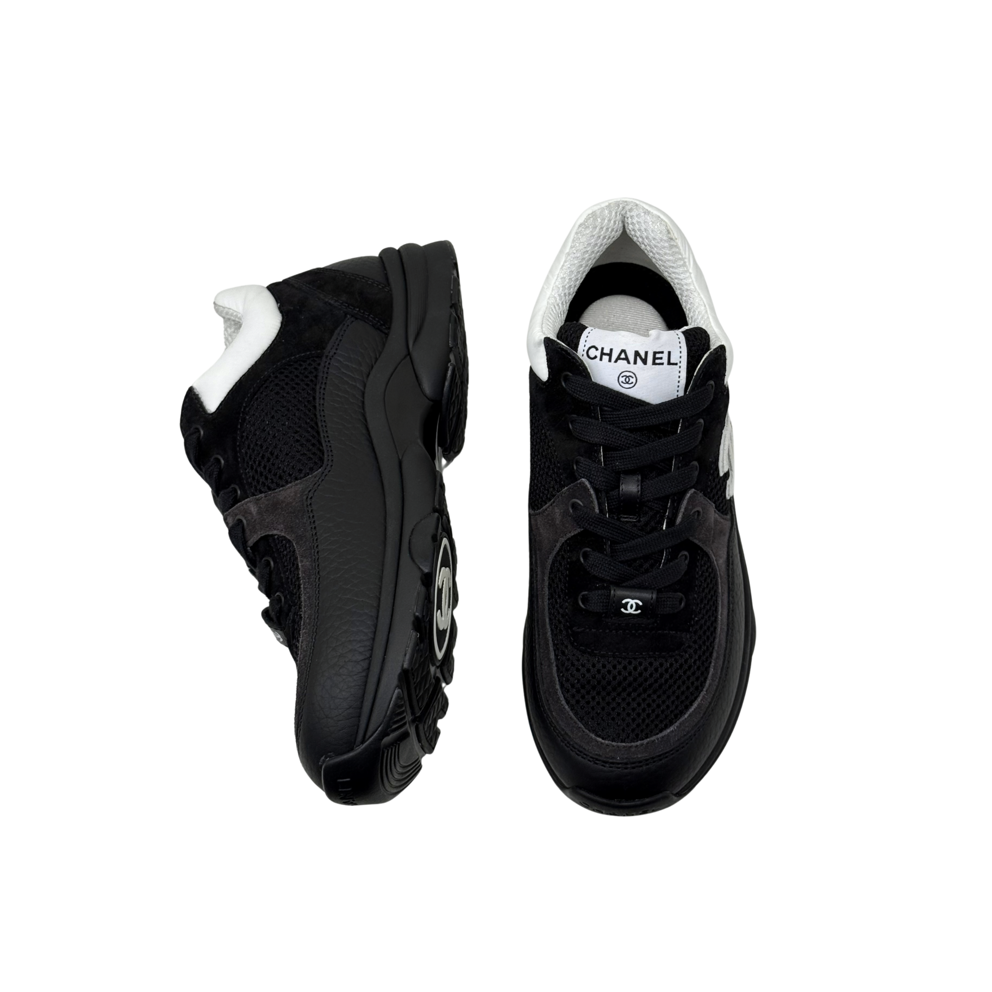 Black low-top sneakers with white collar, lace-up front, chunky rubber sole.