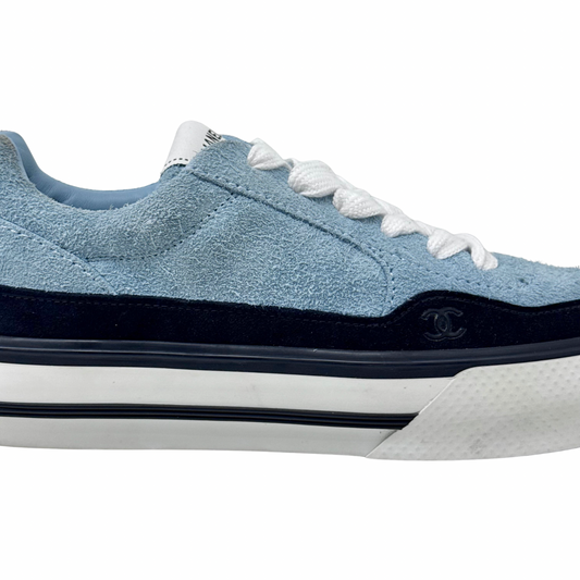 Blue suede sneaker side profile with small CHANEL emblem on black trim