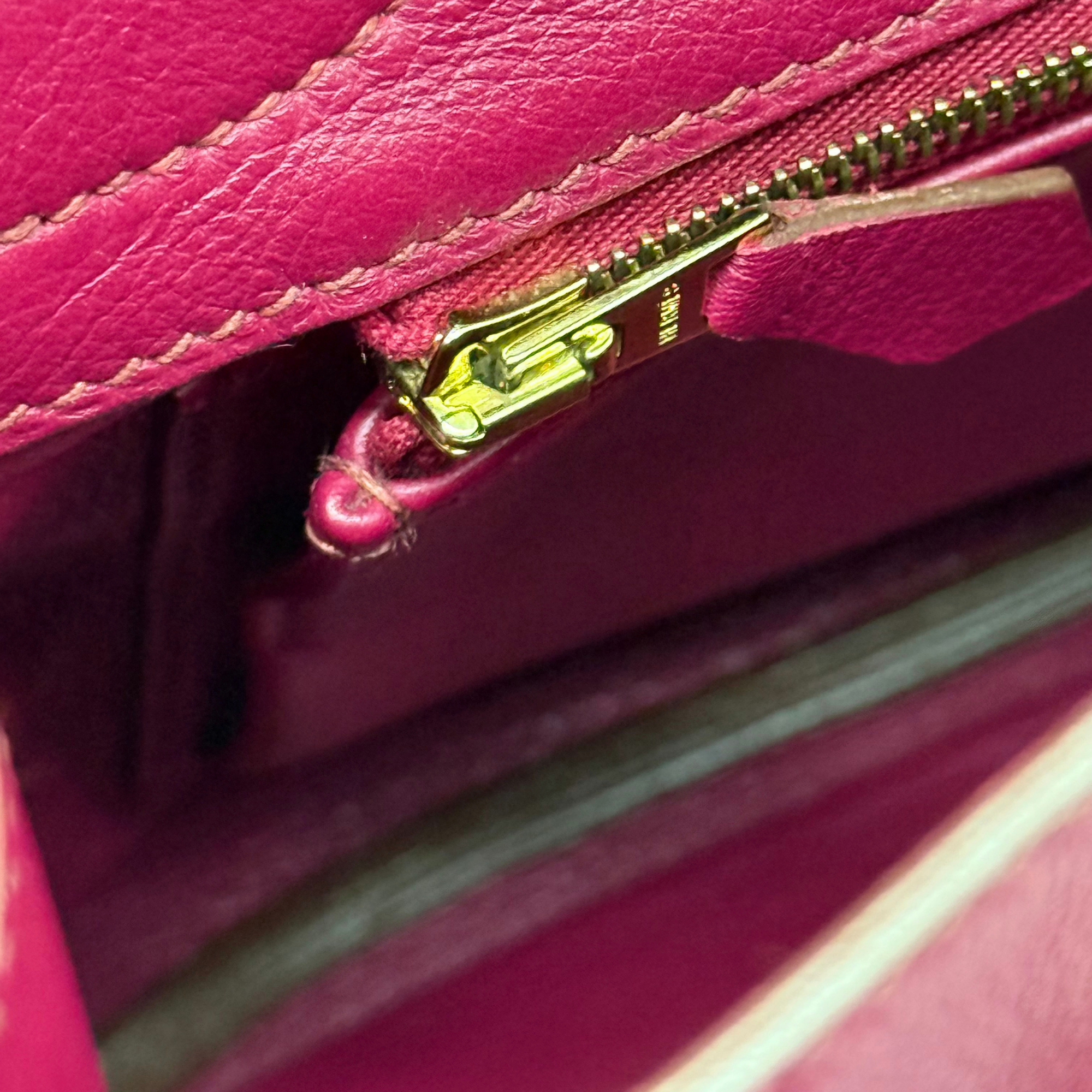 Magenta leather Birkin bag top zipper detail with gold hardware and pull