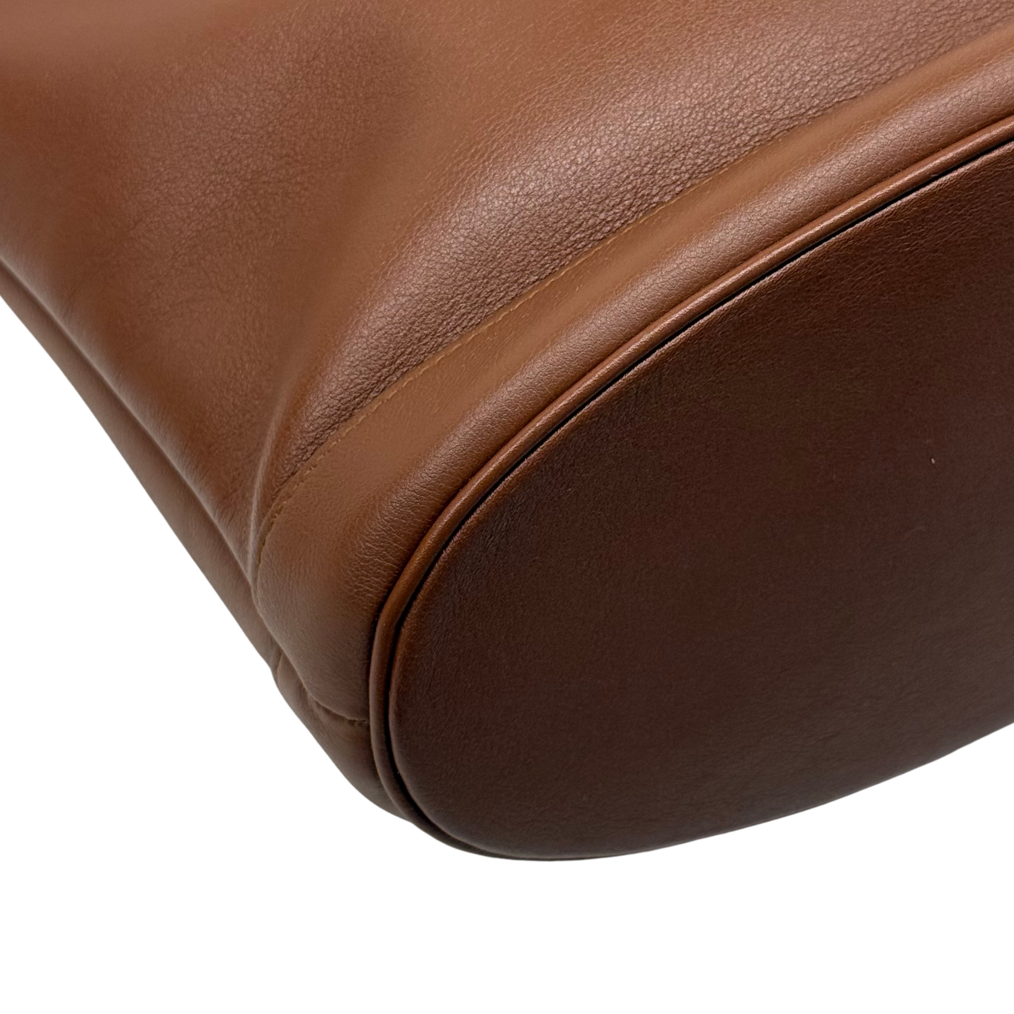 Brown leather bag bottom corner with smooth curved panel and edge piping