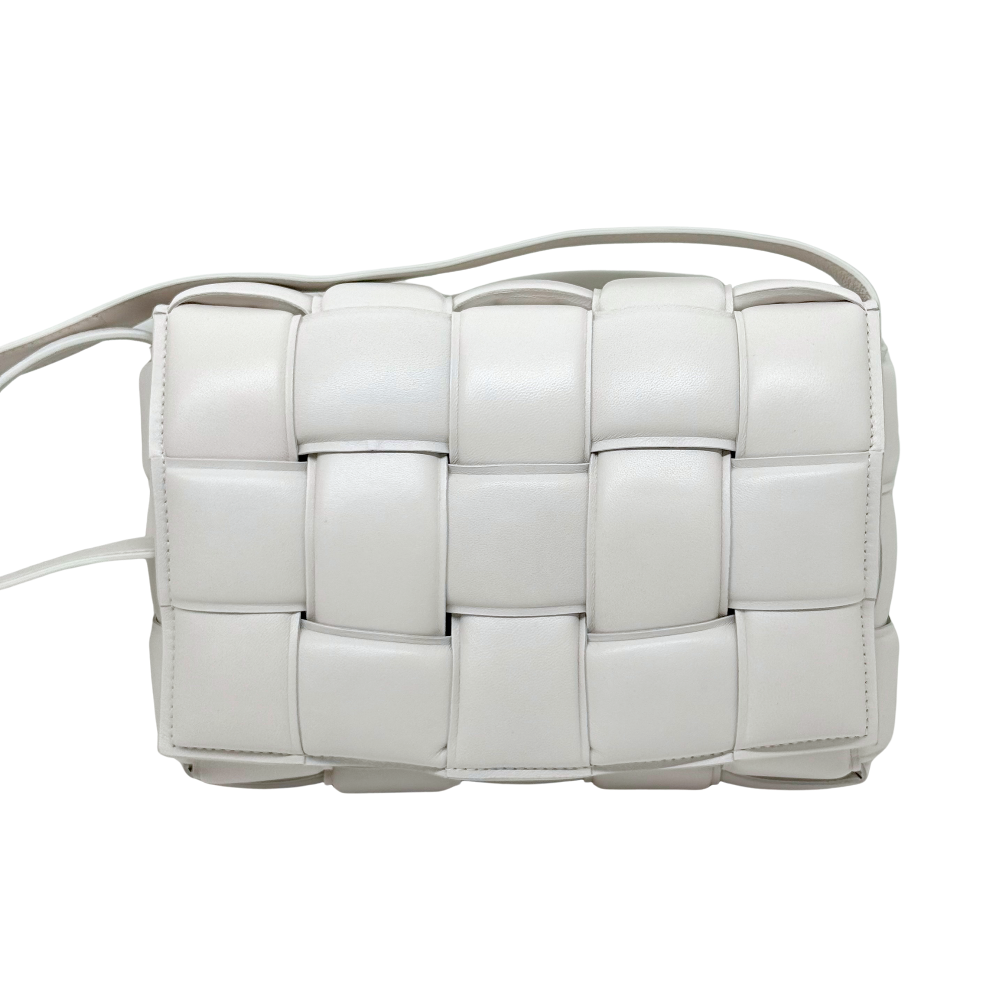 White leather crossbody bag front view with woven-style panels and top strap loop