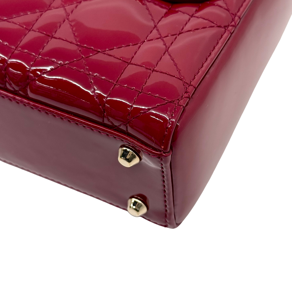 Red quilted patent leather corner with gold-tone snaps and stitched edges