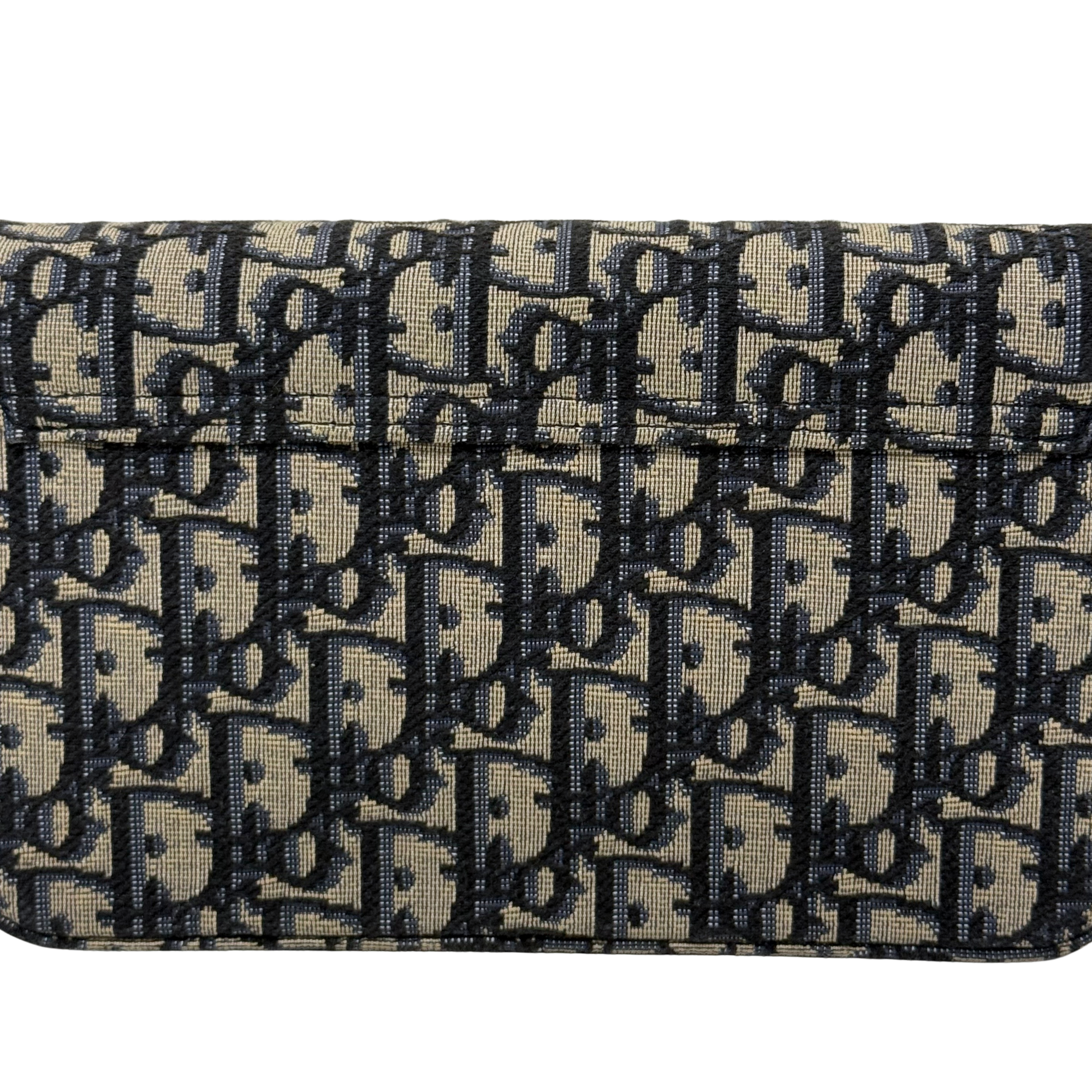 Dior monogram canvas close-up with flap edge stitching and dark repeating pattern