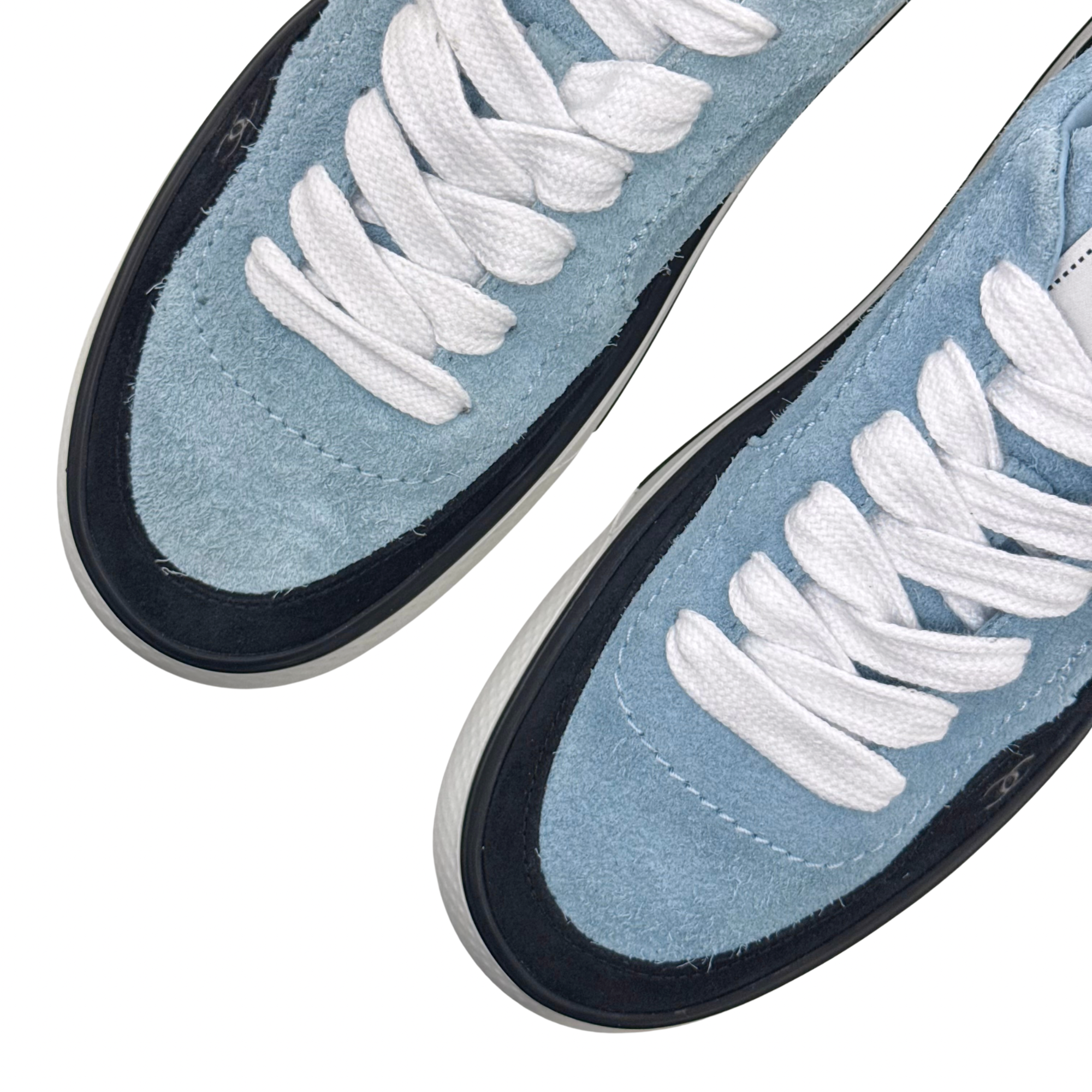 Close-up of blue suede toe and white laces with black rubber trim