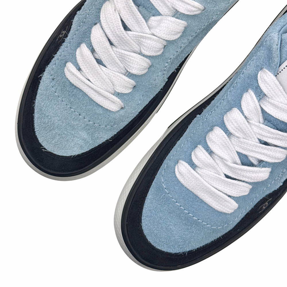 Close-up of blue suede toe and white laces with black rubber trim