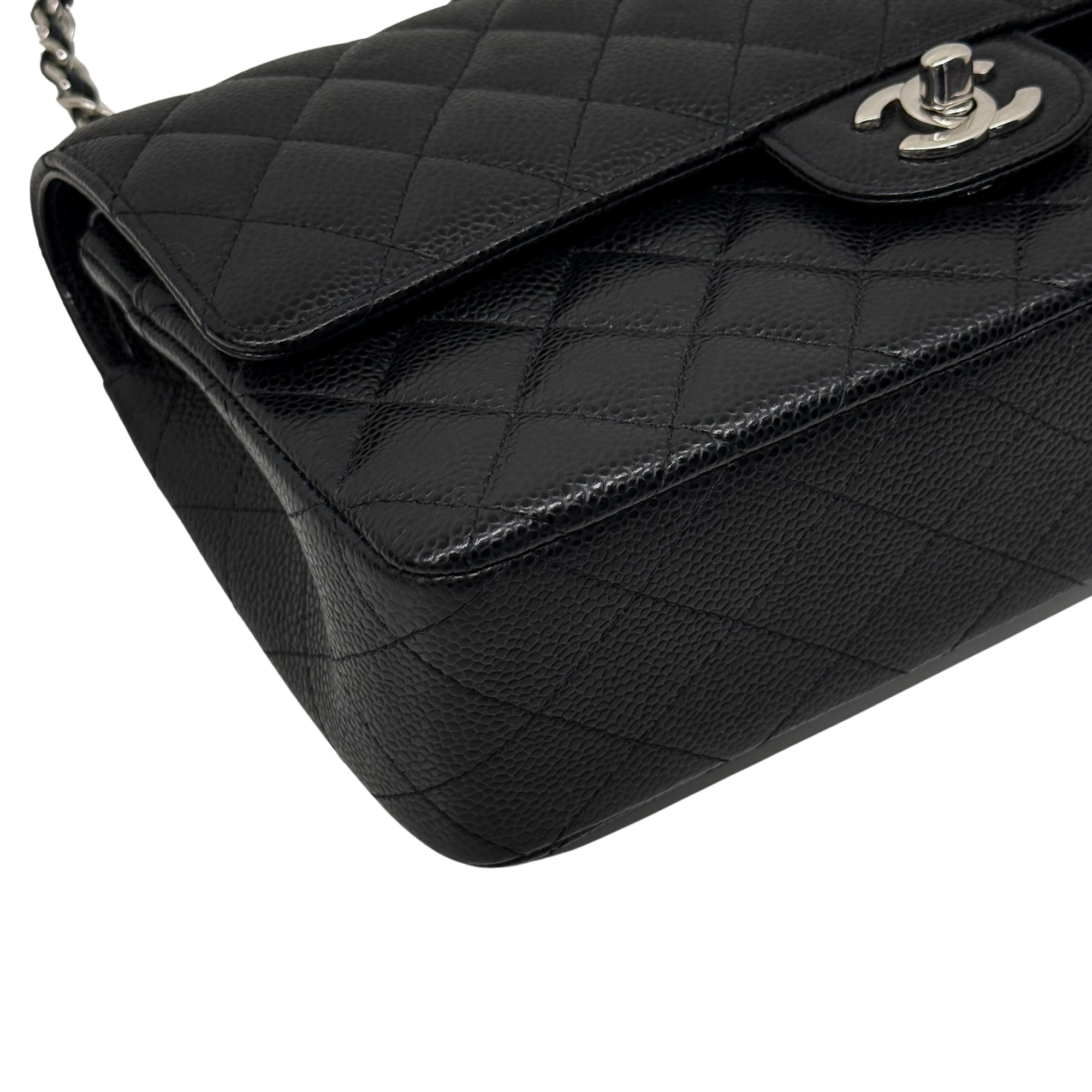 Black quilted shoulder bag flap with round turn-lock hardware and emblem