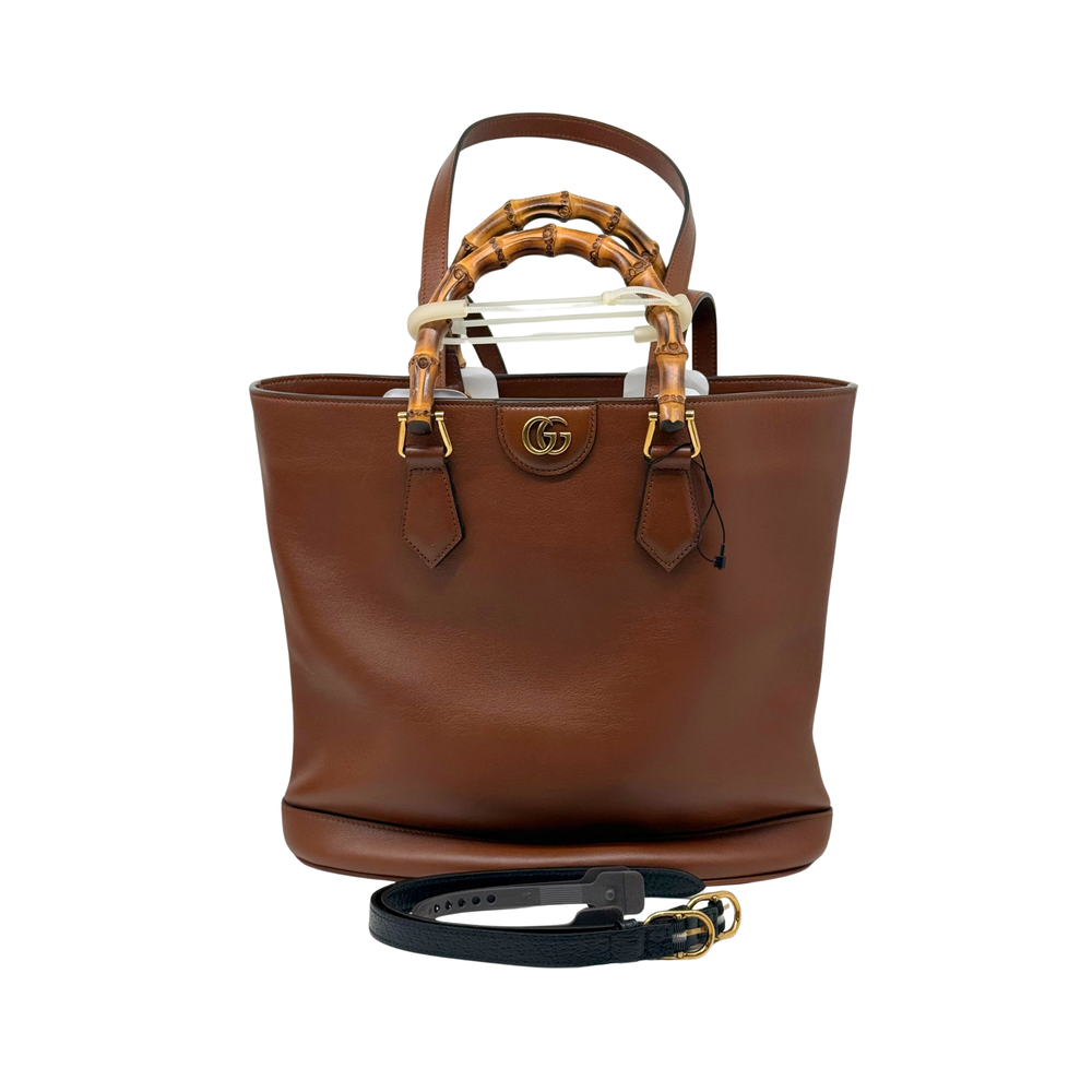 Brown leather tote bag with bamboo-style handle straps and gold-tone hardware