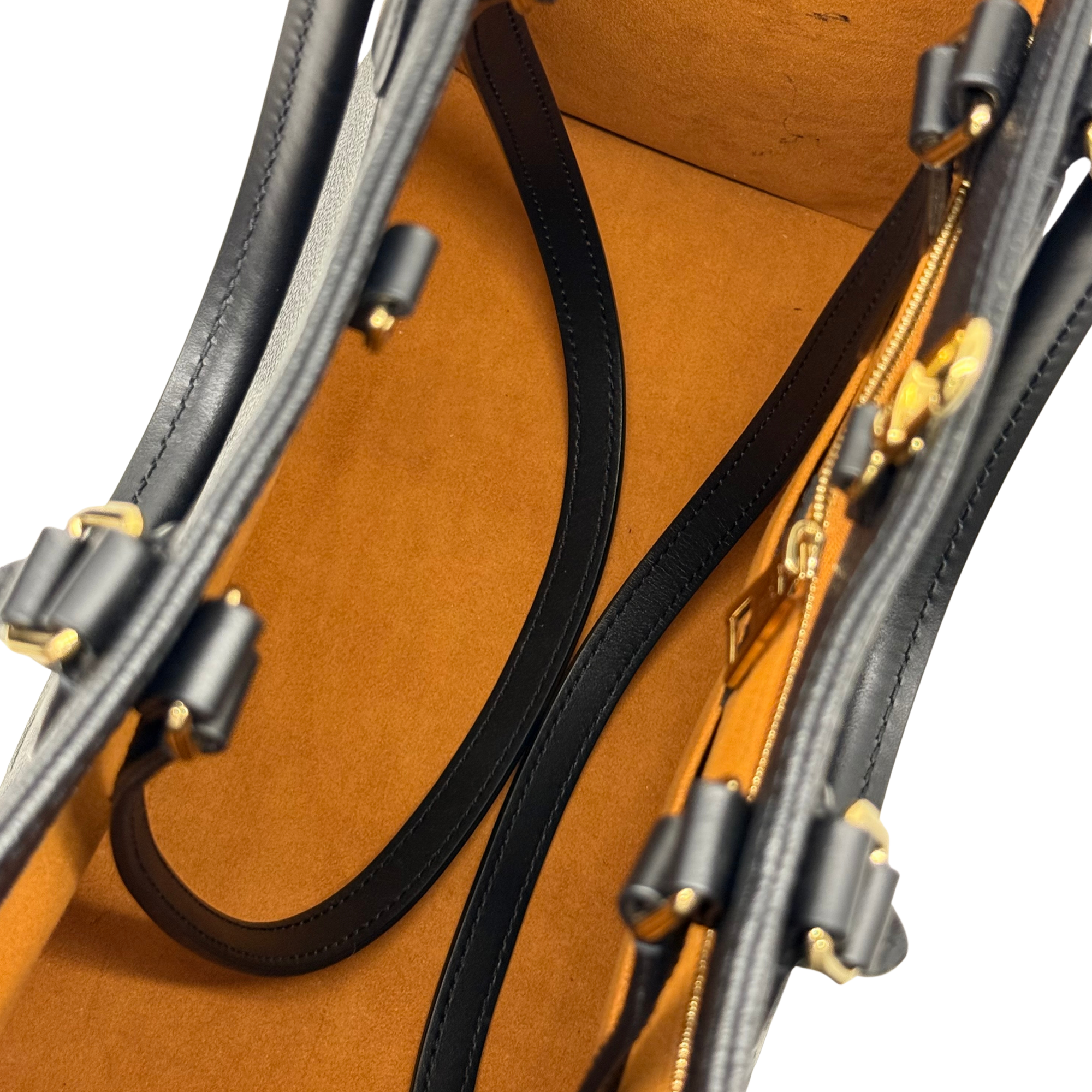 Louis Vuitton tote bag close-up of black trim strap and tan interior near zipper