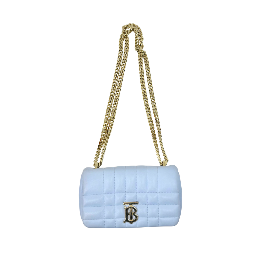 Light blue quilted mini shoulder bag with gold chain strap and gold B emblem.