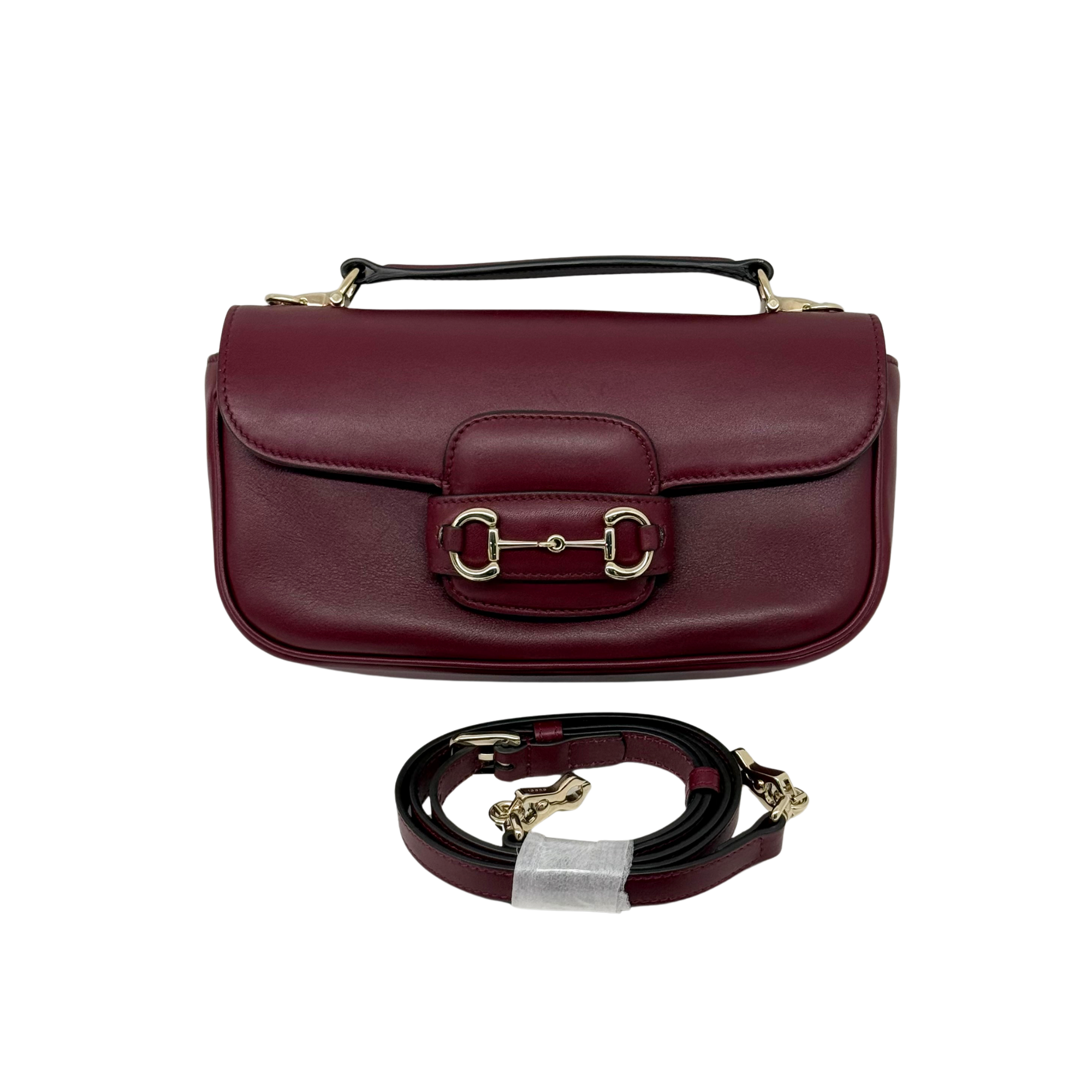 Maroon leather mini crossbody bag with front buckle clasp and strap