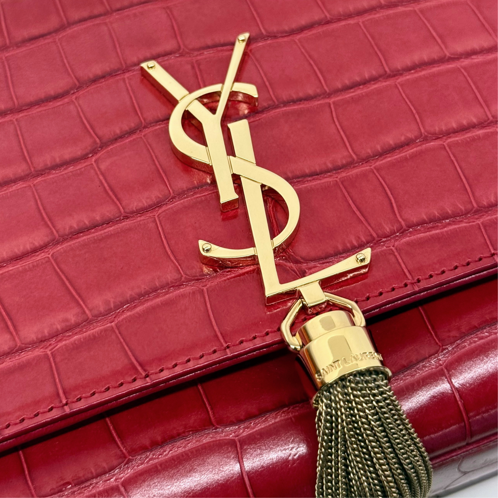 Gold YSL monogram detail on red croc-embossed flap clutch with tassel charm