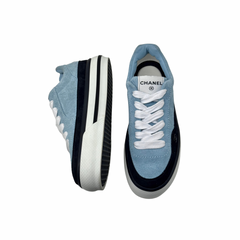 Blue suede low-top sneakers with black and white striped side soles