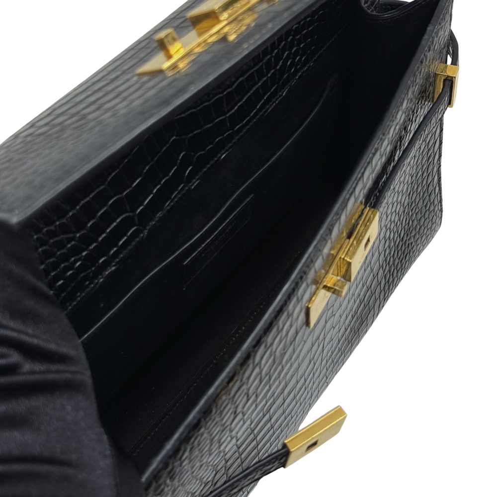 Black croc-embossed leather handbag interior with gold-tone clasp hardware