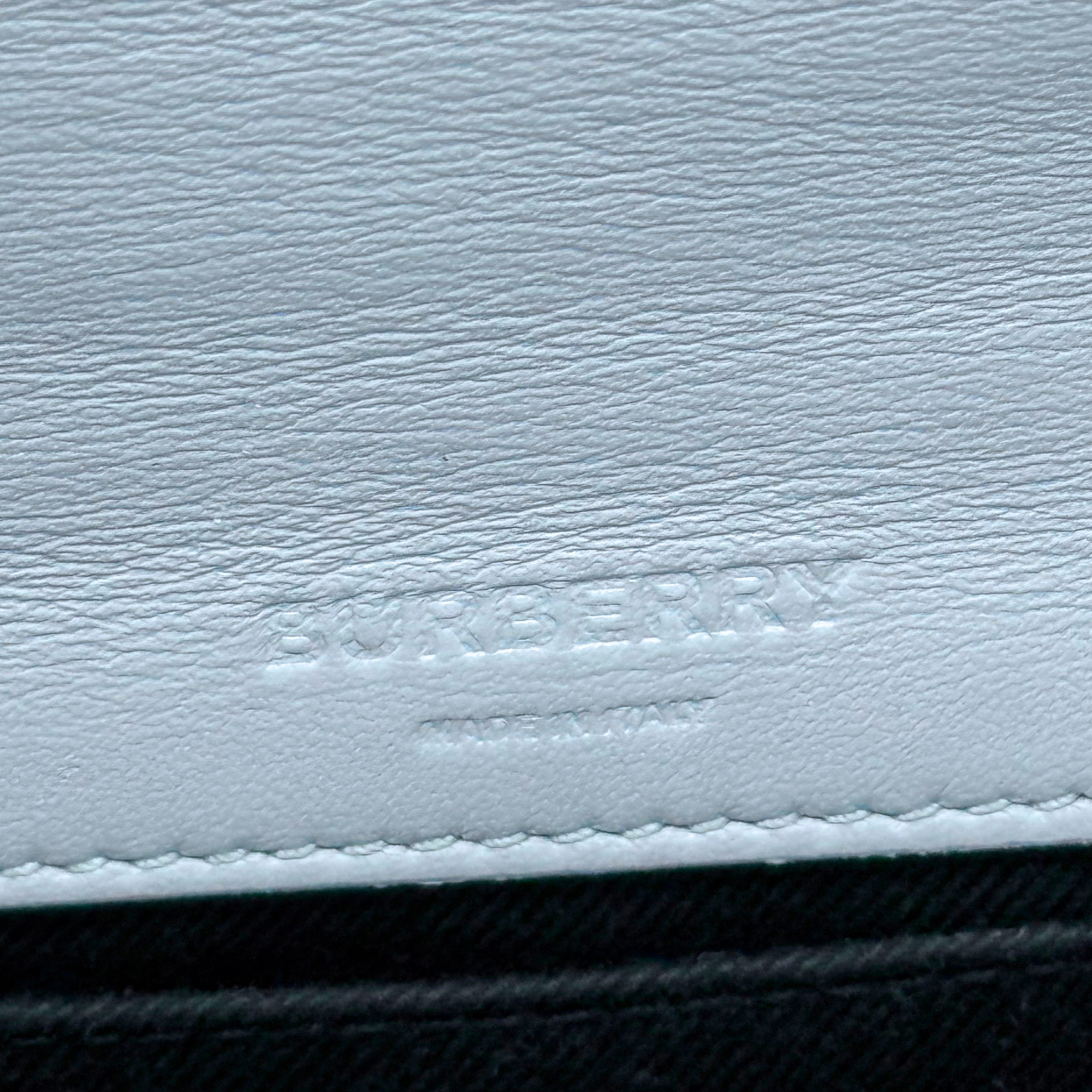Light blue leather bag with Burberry logo stamp and stitched edge detail.