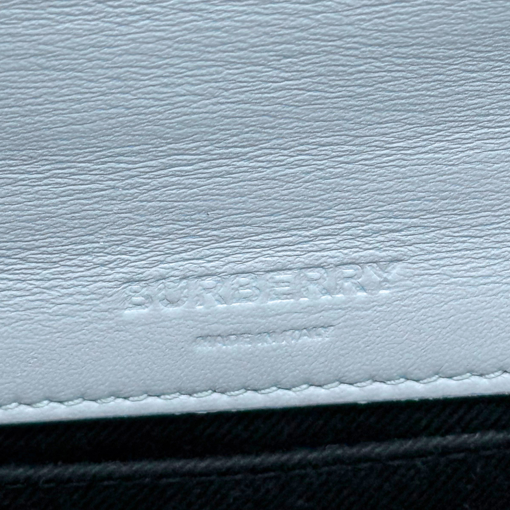 Light blue leather bag with Burberry logo stamp and stitched edge detail.