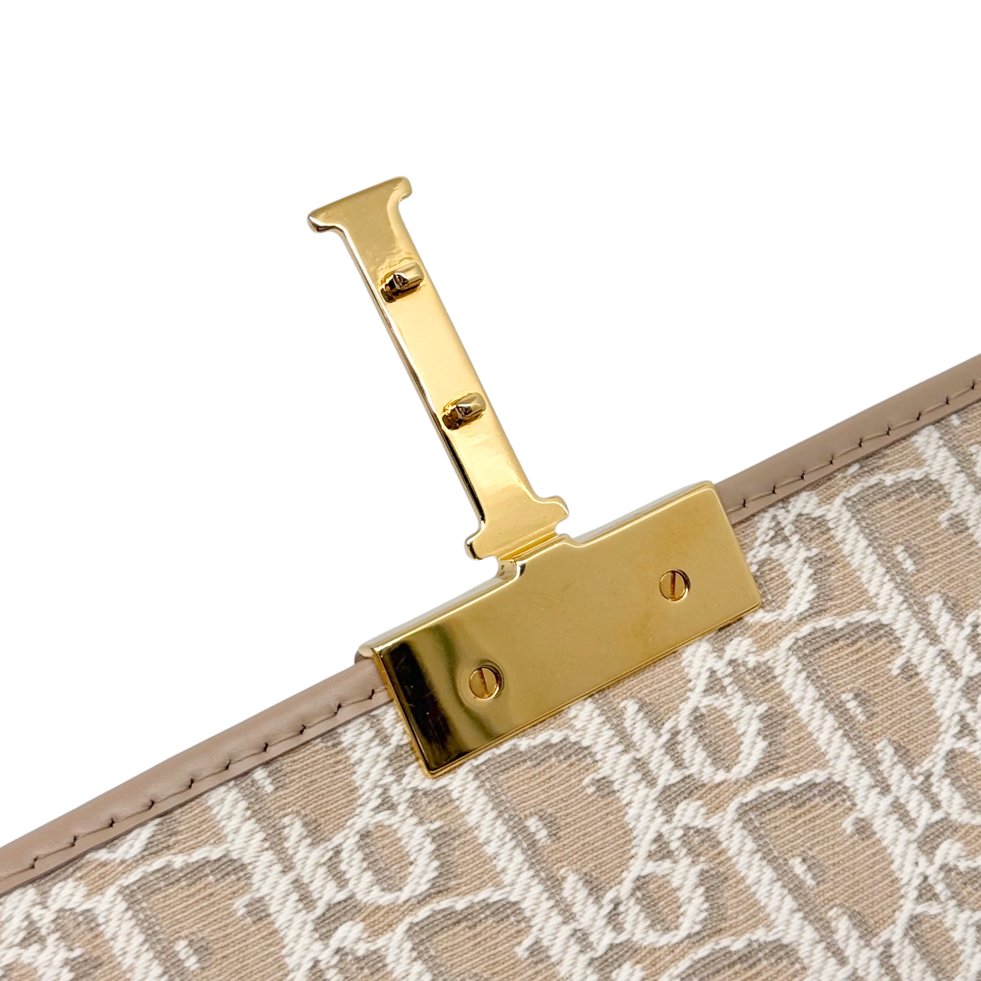 Dior pre-owned bag closure hardware with gold "I" bar and snap button