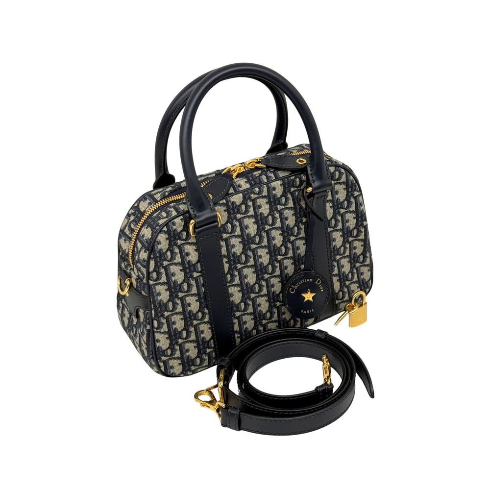 Navy and cream monogram handbag with top handles, crossbody strap, and gold hardware