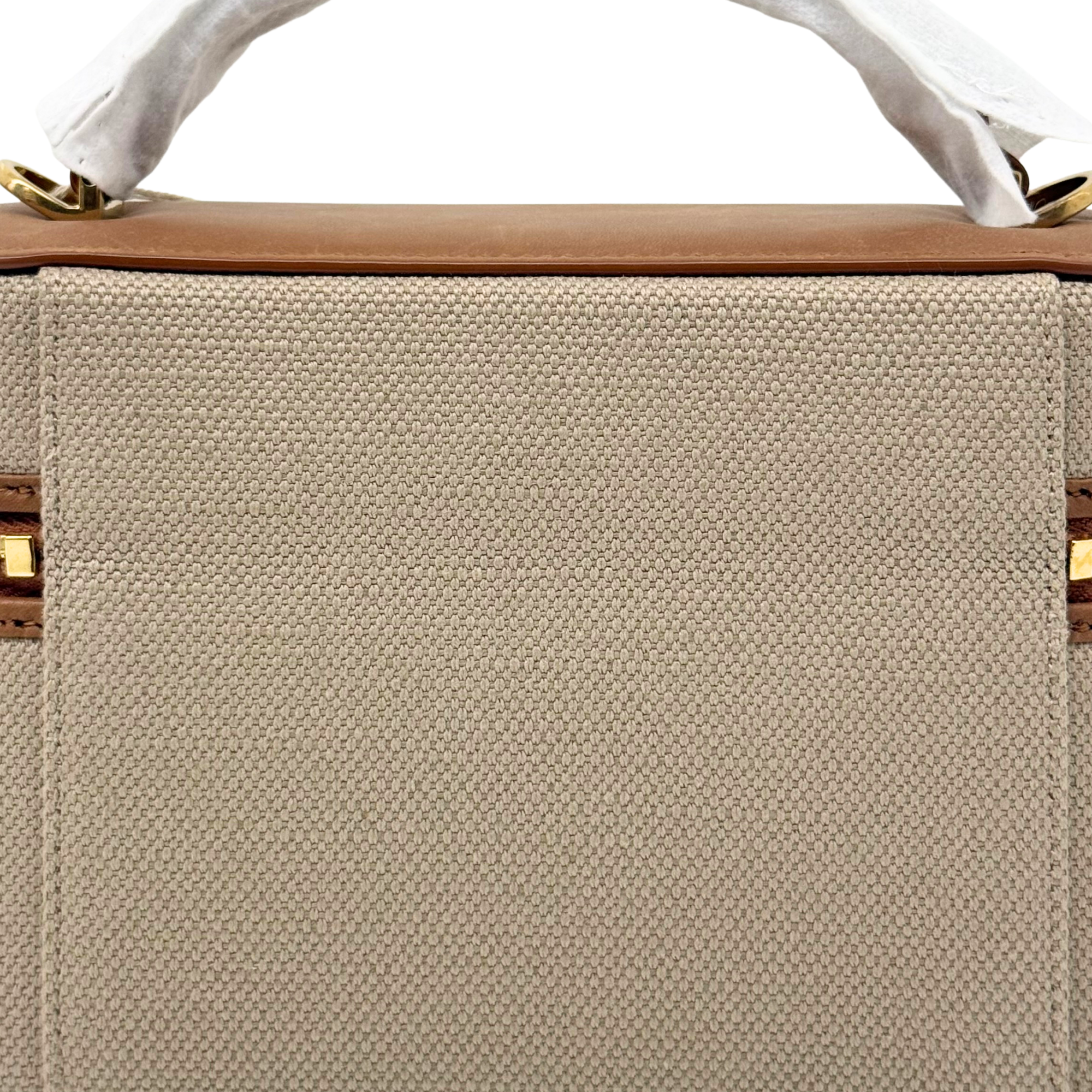 Large beige canvas panel with brown leather top edge and gold zipper rail