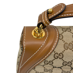 Tan leather handle strap with gold-tone hardware attachment and stitching