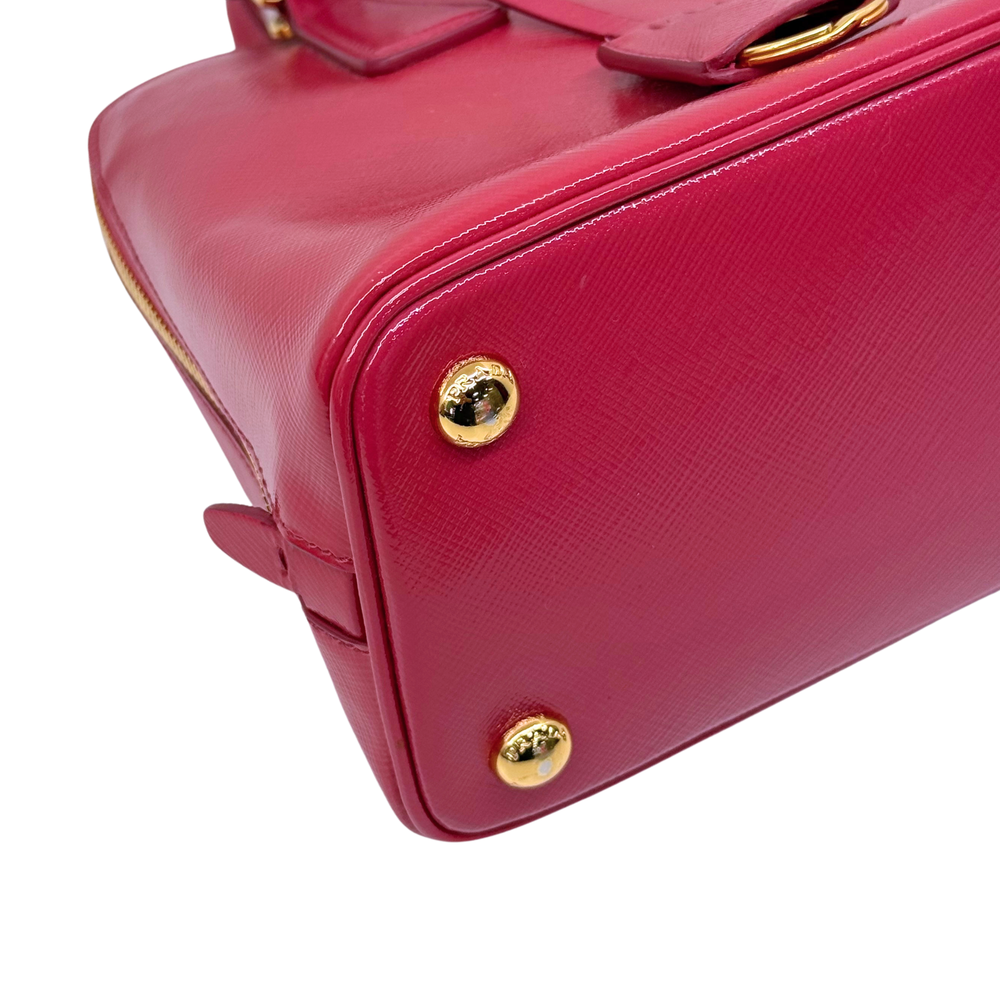 Prada pink handbag side with gold corner button and structured boxy shape