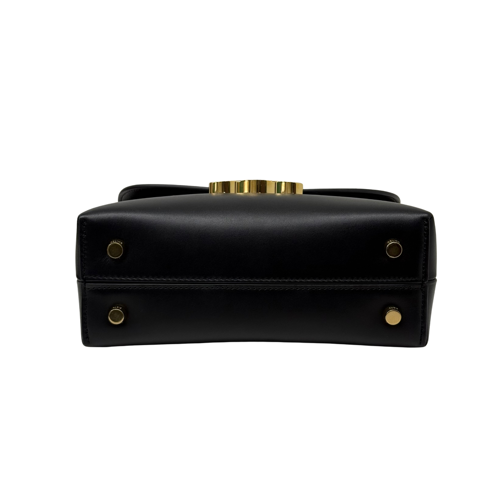 Black leather mini top-handle bag with gold hardware accents and front plaque