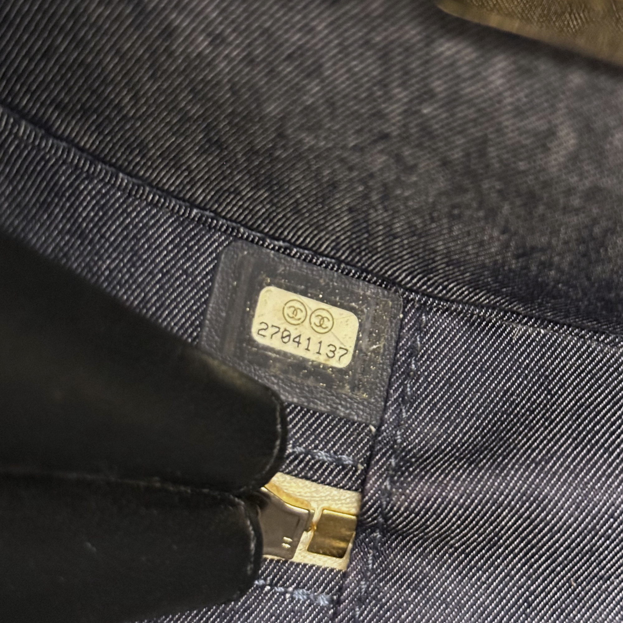 Close-up of interior size label and gold buckle on dark lining of round bag