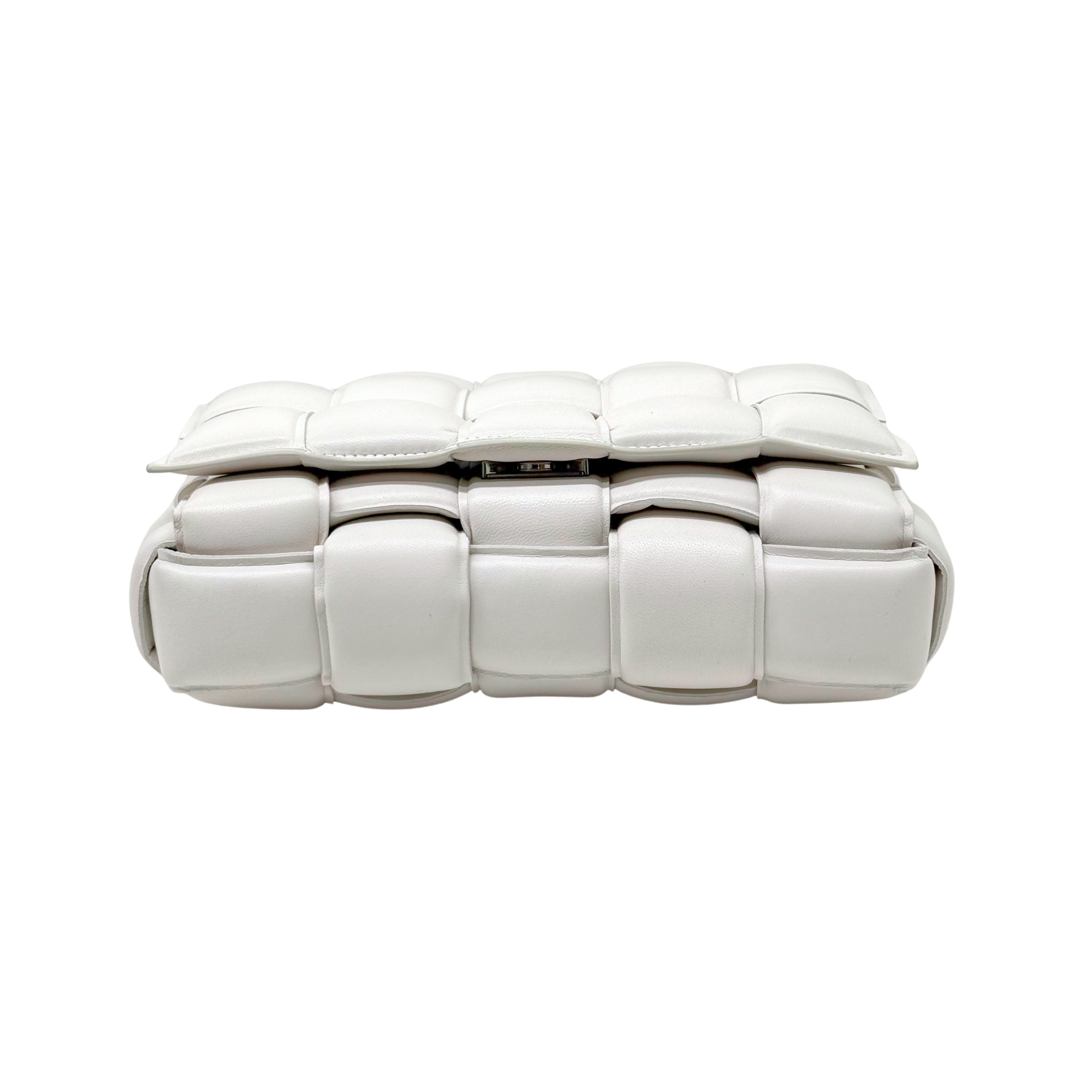 White leather crossbody bag side profile with woven-style panels and magnetic closure