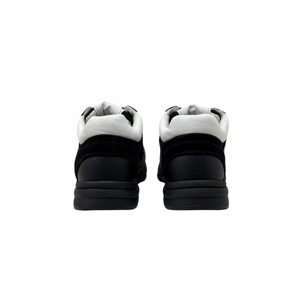 Black low-top sneakers showing heels and padded collars with white lining.